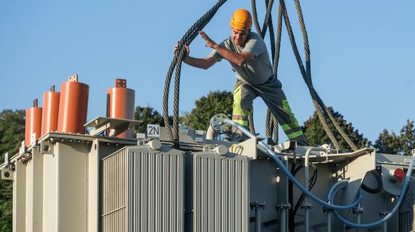 Mann auf der Baustelle arbeitet an einem Transformator